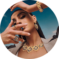 Person wearing gold jewelry with a scenic background