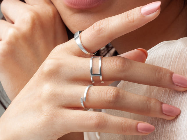 Close-up of hands wearing silver rings with a soft background